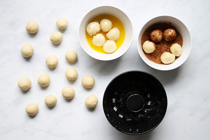 Teigkugeln in Butter und Zucker wälzen